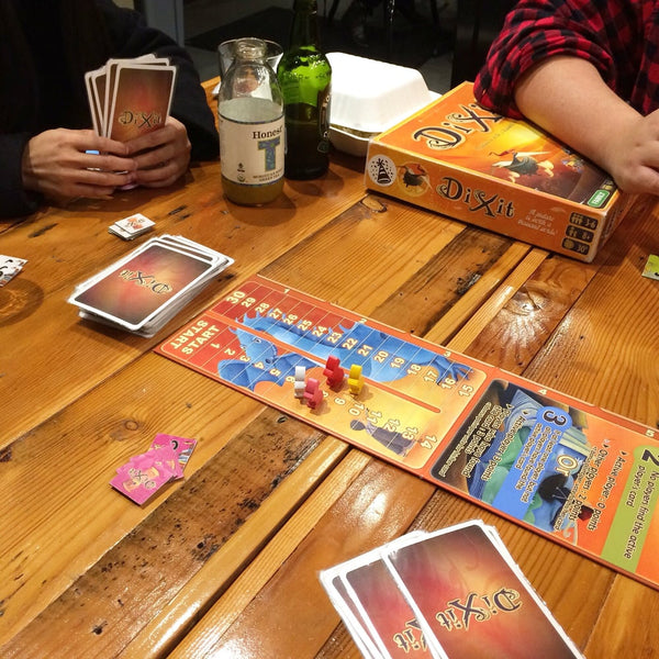 Friends playing Dixit on our beautifully rustic tables. 